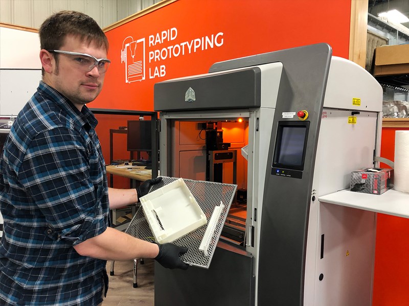 Man shows a 3D printed part that has just been printed