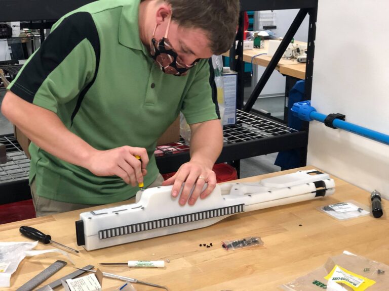 Man screws together parts of a disc gun