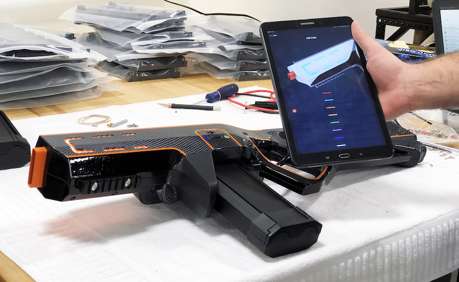 Disc gun prototype and mobile app shown on a table