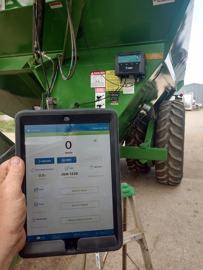 Person holding tablet showing REAP Harvest Inventory App in front of a POINT scale
