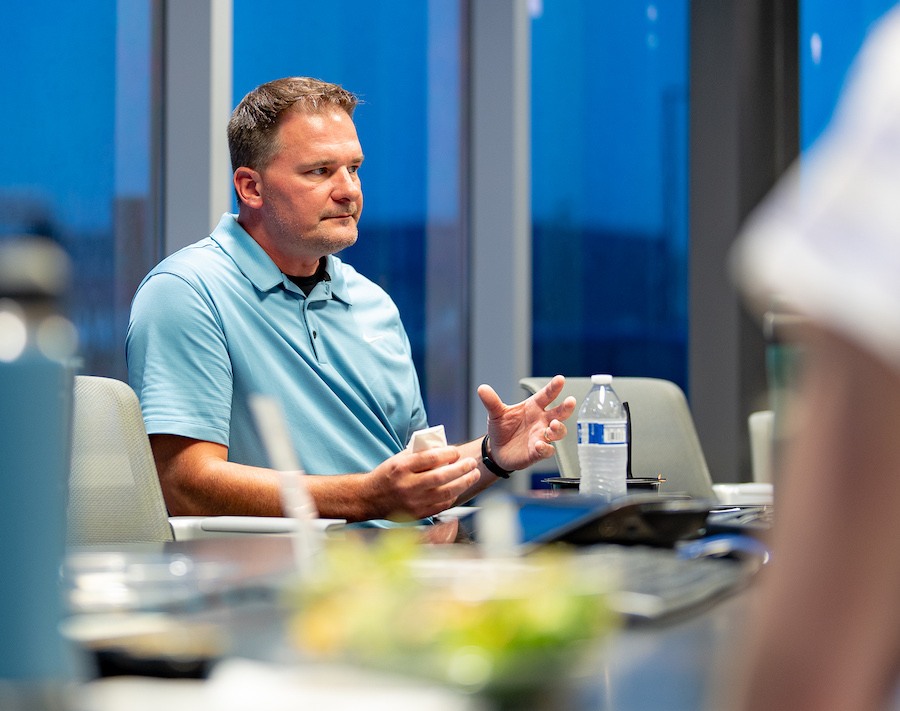 Team member speaking during a meeting in a bright conference room