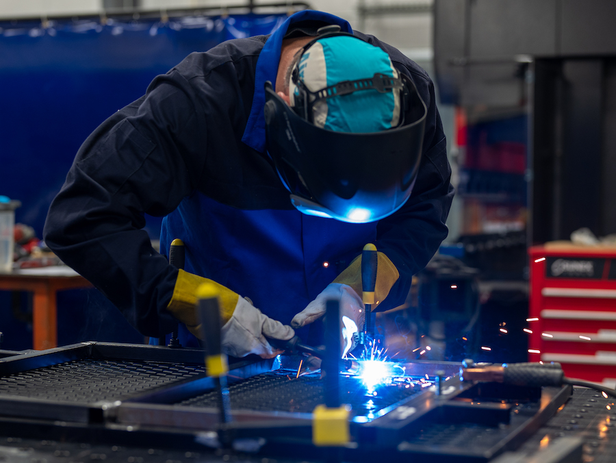 Man welding with blue sparks flying