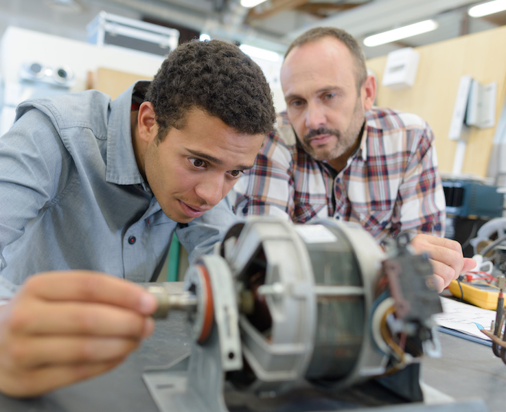 Team of engineers looking at an electric motor during development