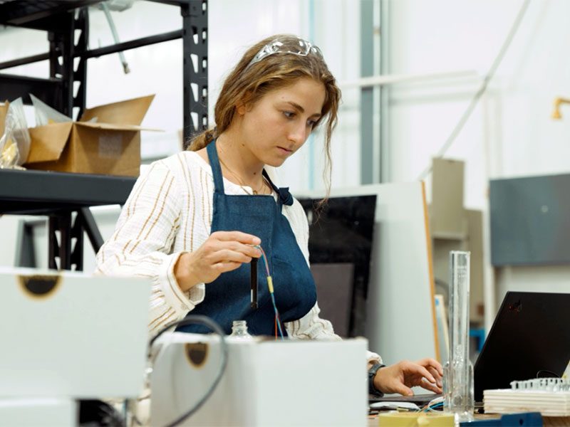 Female engineer working in prototype shop on a computer